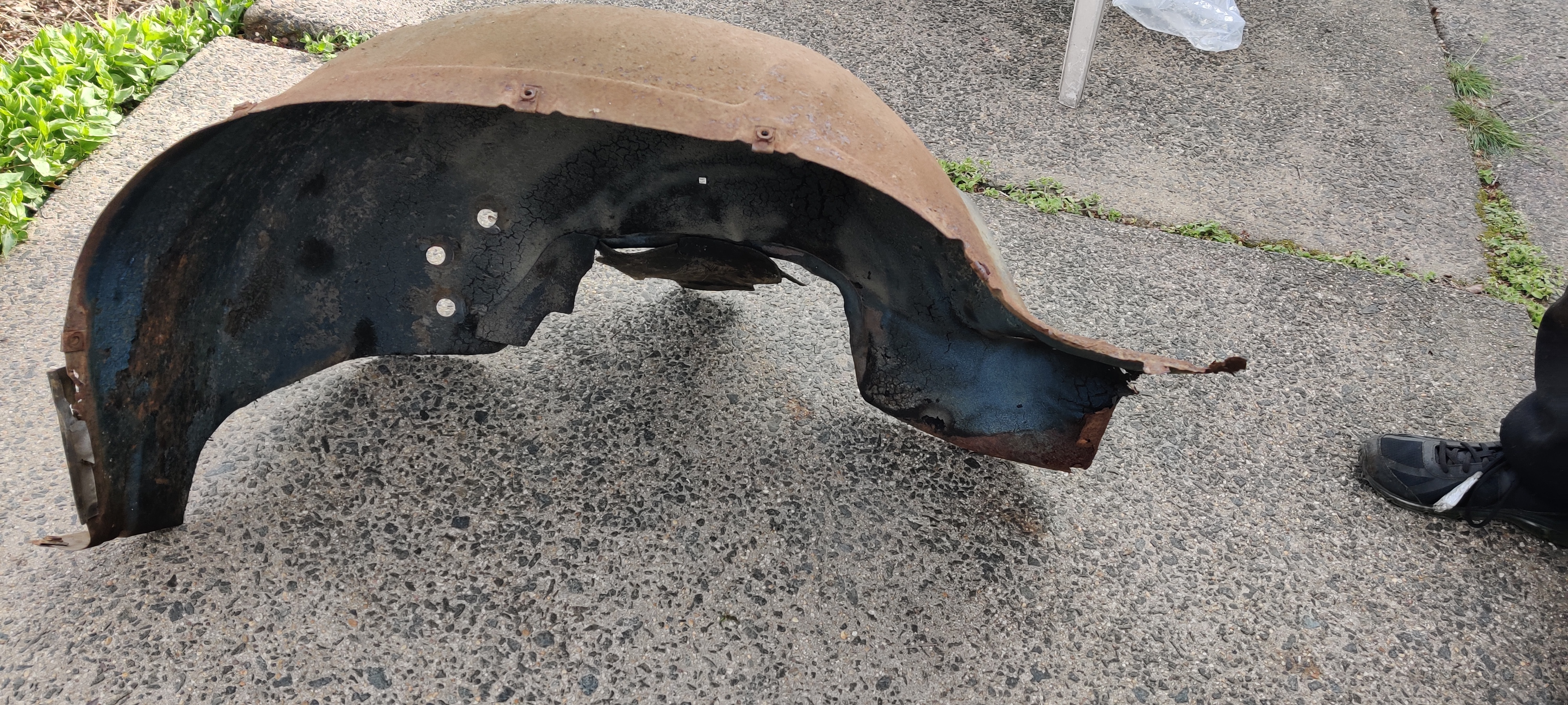 Old rusted out front right wheel well